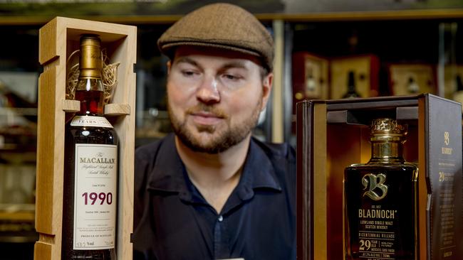 Dan Murphy’s Mermaid Waters whisky expert Matt Loth with the $17,000 spirit, and a bottle of Bladnoch Bicentennial 2970, which will set you back $8,800. Picture: Jerad Williams