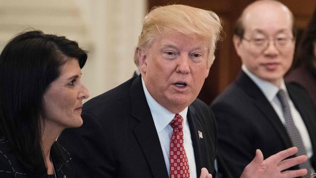 US Ambassador to the UN Nikki Haley, left, listens while Mr Trump addresses UN Security Council member nations in the White House. Picture: Brendan Smialowski/AFP