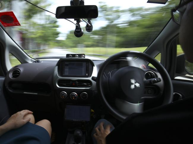 A driver, right, takes his hands off the steering wheel of an autonomous vehicle during its test drive in Singapore. Picture: AP / Yong Teck Lim