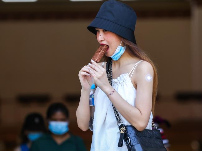 A woman has an ice cream after her booster vaccination at the Royal Exhibition Building as the omicron Covid-19 variant spreads throughout Australia. Picture: NCA NewsWire / Ian Currie