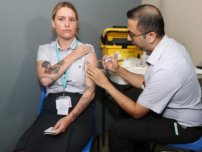 Metro South Hotel Quarantine Program Nurse Molly Baretta receiving the first Pfizer Vaccination from Clinical Nurse Consultant Rajiv Bawa at Princess Alexandra Hospital. Picture: Tara Croser.