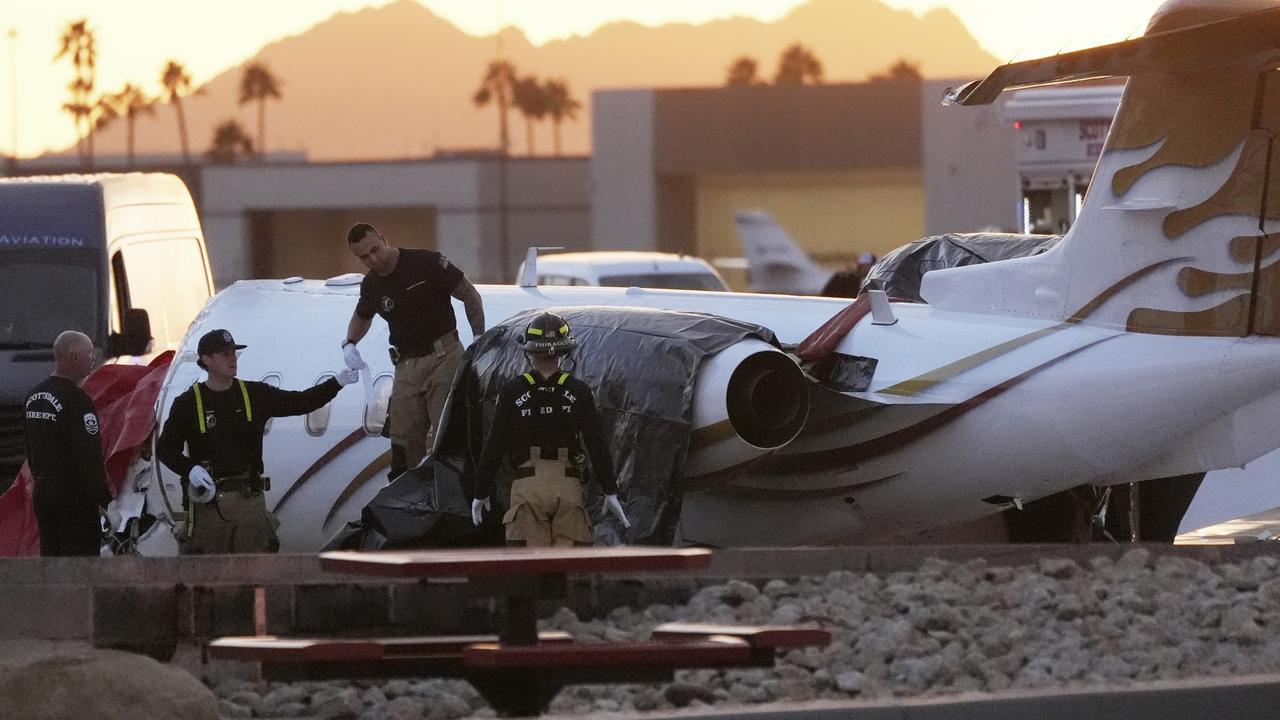 Scottsdale Fire Department firefighters at the scene of the crashed Learjet at Scottsdale Airport. Picture: AP Photo/Ross D. Franklin