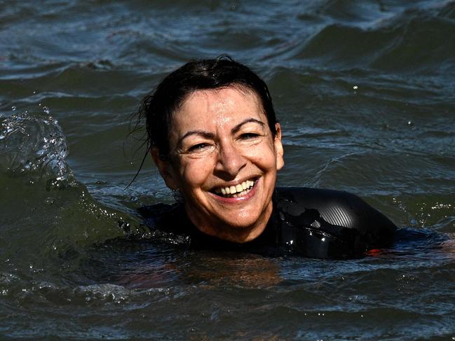 TOPSHOT - Paris Mayor Anne Hidalgo swims in the Seine, in Paris on July 17, 2024, to demonstrate that the river is clean enough to host the outdoor swimming events at the Paris Olympics later this month. Despite an investment of 1.4 billion euros ($1.5 billion) to prevent sewage leaks into the waterway, the Seine has been causing suspense in the run-up to the opening of the Paris Games on July 26 after repeatedly failing water quality tests. But since the beginning of July, with heavy rains finally giving way to sunnier weather, samples have shown the river to be ready for the open-water swimming and triathlon -- and for 65-year-old Hidalgo. (Photo by JULIEN DE ROSA / AFP)