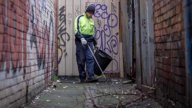 A Yarra council worker picks up drug debris in a laneway off Little Lithgow St, Abbotsford. Picture: Jake Nowakowski