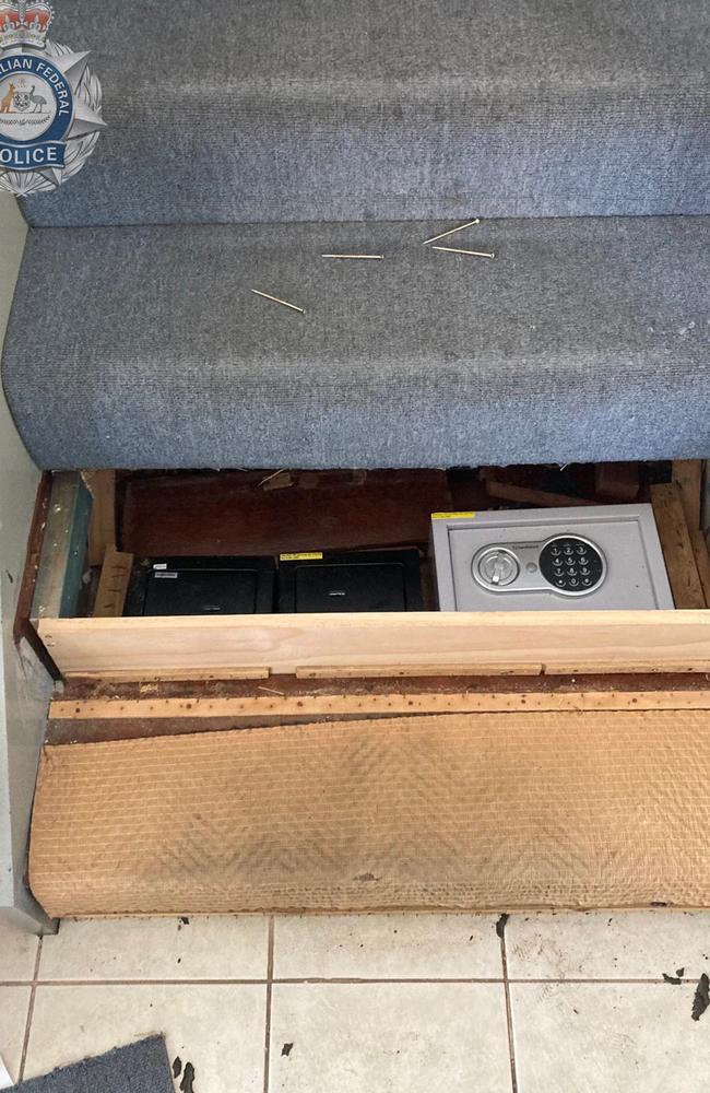 The $70,000 seized from two safes hidden under stairs and a cash counter at a Bardon home (pictured). Photo - AFP