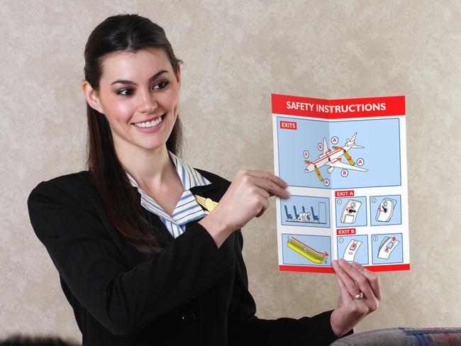 An airline flight attendant reviewing a flight safety card before takeoff. Note to inspector: Safety card is my original artwork.