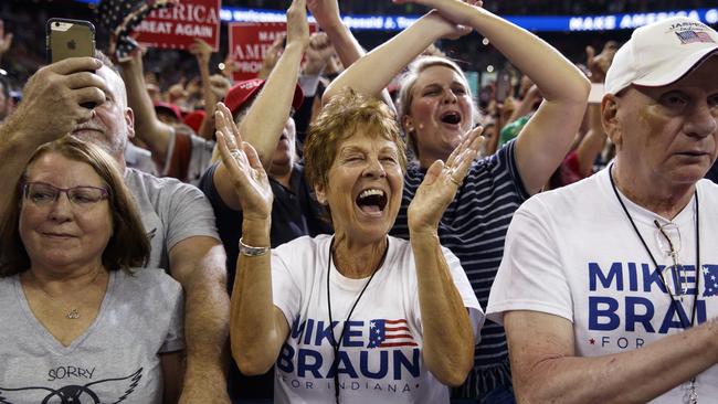 Supporters of President Donald Trump, wearing Mike Braun for Congress shirts, cheer as he arrives for a campaign rally. Picture: AP