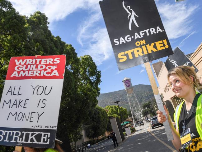 Members of the Writers Guild of America and the Screen Actors Guild walk a picket line outside of Warner Bros Studio in Burbank, California, on July 26, 2023. Tens of thousands of Hollywood actors went on strike at midnight July 14, 2023, effectively bringing the giant movie and television business to a halt as they join writers in the first industry-wide walkout for 63 years. (Photo by VALERIE MACON / AFP)