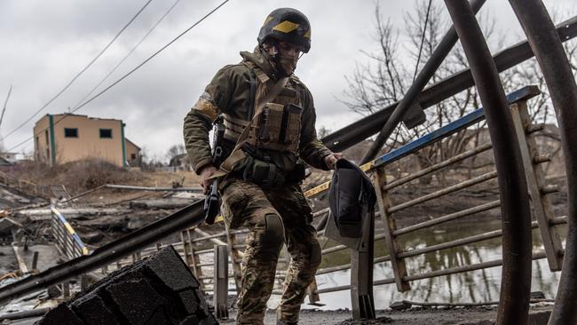 A member of the Ukrainian military runs across a destroyed bridge amid fighting in Bucha and Irpin. Picture: Chris McGrath/Getty Images