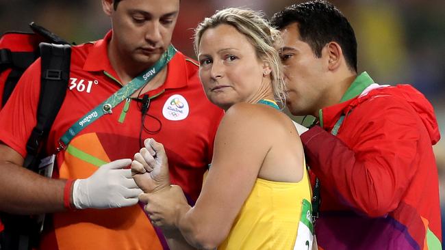 Kim Mickle of Australia is assisted by medical staff.