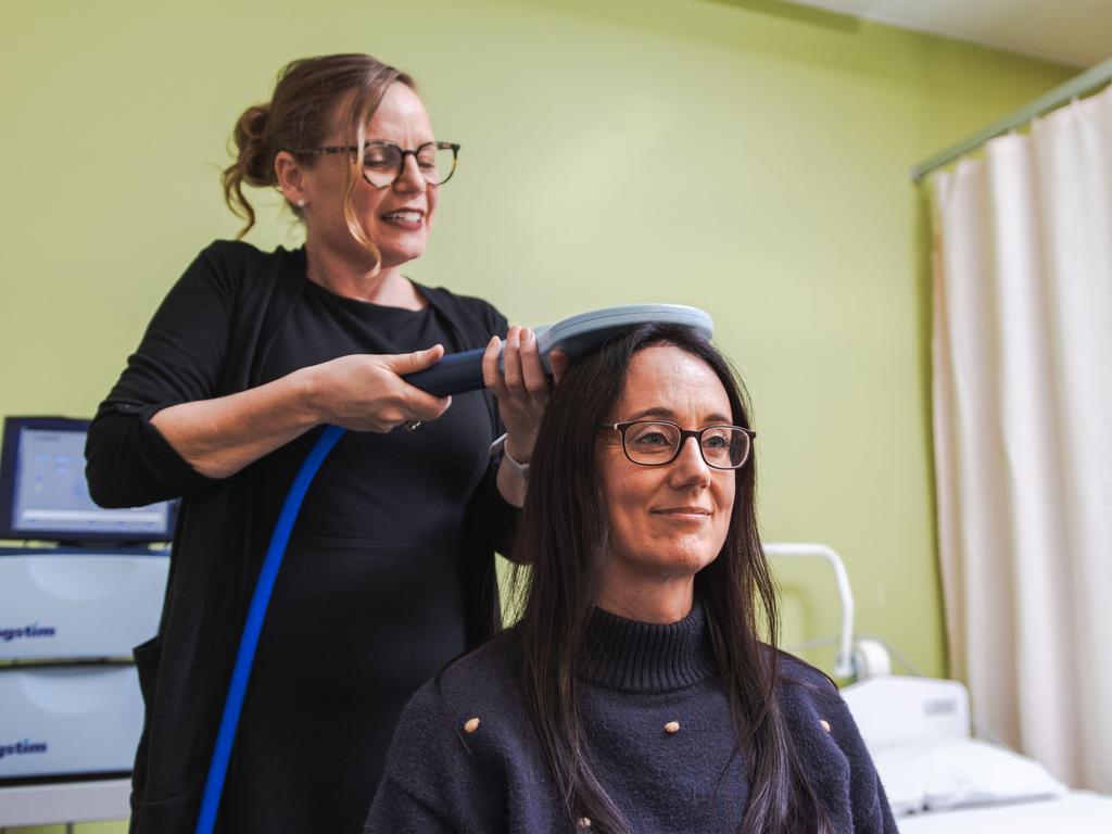 Mater clinical research co-ordinator Tamara Powell uses the electromagnetic coil on Jette Beek.