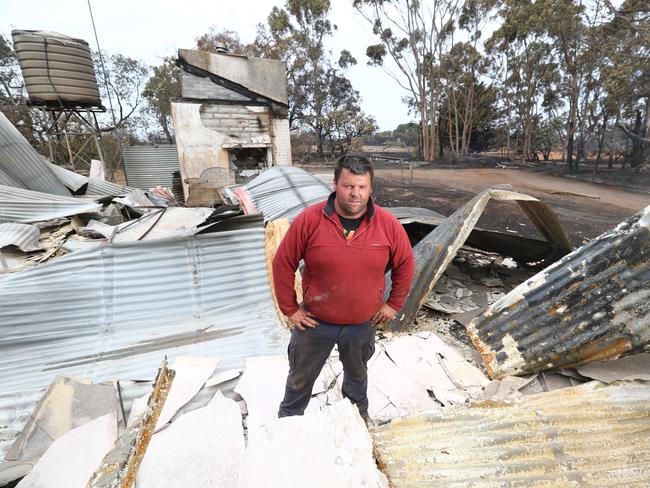 Jared McArdle stands amid ruins - he two family homes in the fire and about 15 per cent of his sheep flock. Picture: Tait Schmaal