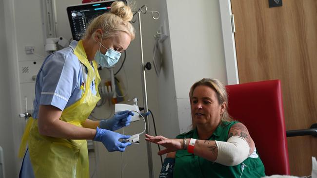 Patient Trudy Woodfall who is recovering from coronavirus at Royal Papworth Hospital in Cambridge, England, is treated by a member of clinical staff. Picture: AFP