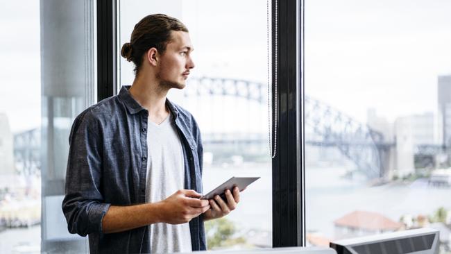 Businessman with digital tablet looking out of window