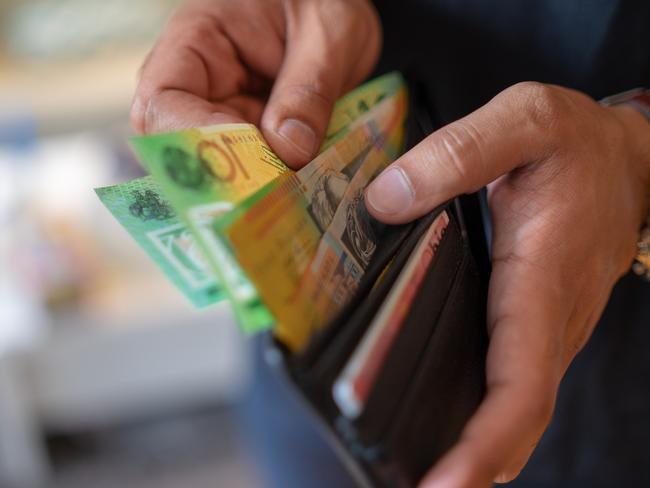 a male taking money out of a wallet, Australian cash generic spending