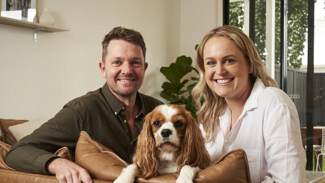 Darren Baynes and Sophie Mills with their cavoodle (cavalier king charles spaniel cross poodle), Ruby, 7, at home in Magill. Picture: Matt Loxton