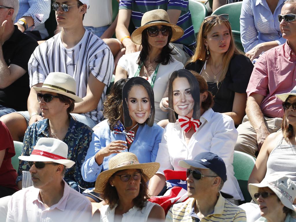 Spectators wearing masks featuring Kate, Duchess of Cambridge, centre right, and Meghan, Duchess of Sussex watch from the stands at Wimbledon. Picture: AP