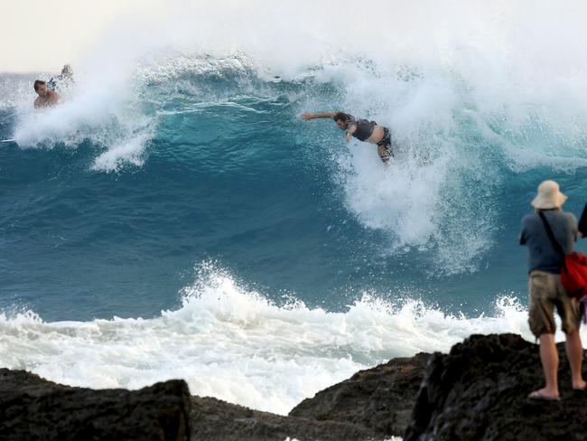 Photographers take pictures of a surfer at Snapper Rocks on the Gold Coast , Thursday February 21, 2019. Huge swells and high tides are set to pummelling south-east Queensland beaches over the coming days as Cyclone Oma tracks towards the Queensland coast. (AAP Image/Dave Hunt)