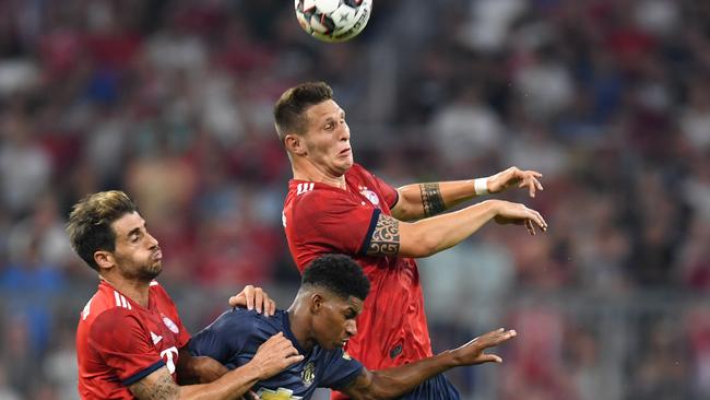 Manchester's Marcus Rashford (C) goes up for a header with Munich's Javi Martinez (L) and Niklas Sule.