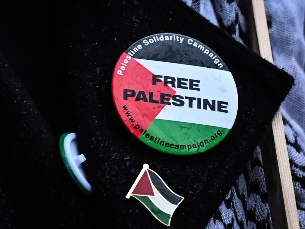 Badges pinned on the jacket of a protester taking part in a vigil outside Downing Street. Picture: AFP