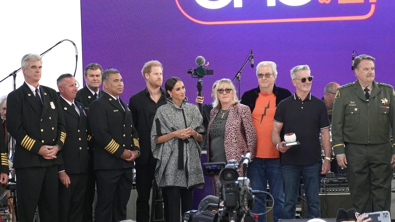 Prince Harry and Meghan Markle join Kevin Costner on stage at his event to raise money for local first responders. Picture: Backgrid