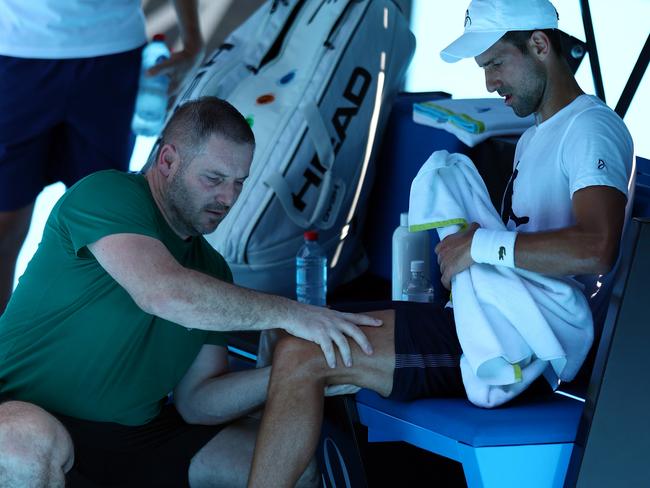 MELBOURNE, AUSTRALIA - JANUARY 11: Novak Djokovic of Serbia receives treatment during a practice match against Daniil Medvedev of Russia ahead of the 2023 Australian Open at Melbourne Park on January 11, 2023 in Melbourne, Australia. (Photo by Graham Denholm/Getty Images)