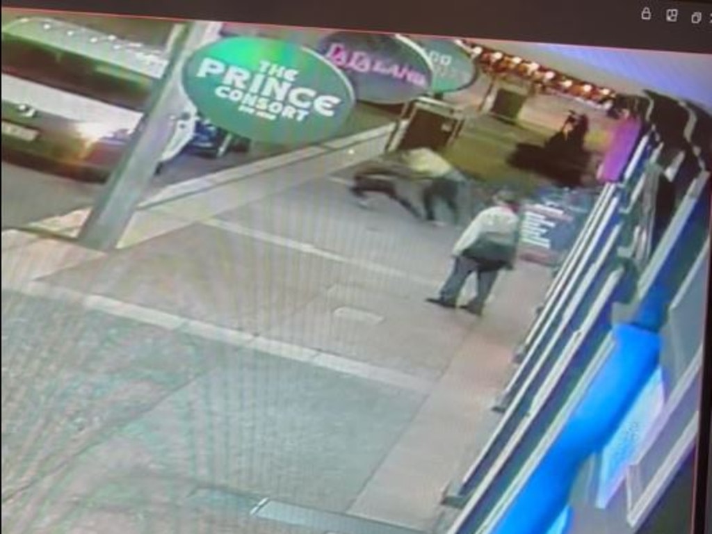 Two men come tumbling out of the shop, as an elderly man watches on. Picture: Supplied