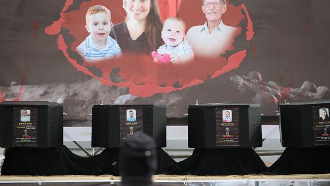 The coffins of the four Israeli hostages sit on stage during the handing them over to the Red Cross in Khan Yunis in the southern Gaza on February 20, 2025. Hamas handed over on February 20 coffins believed to contain the bodies of four Israeli hostages, including those of the Bibas family who became symbols of the ordeal that has gripped Israel since the Gaza war began. (Photo by Eyad BABA / AFP)