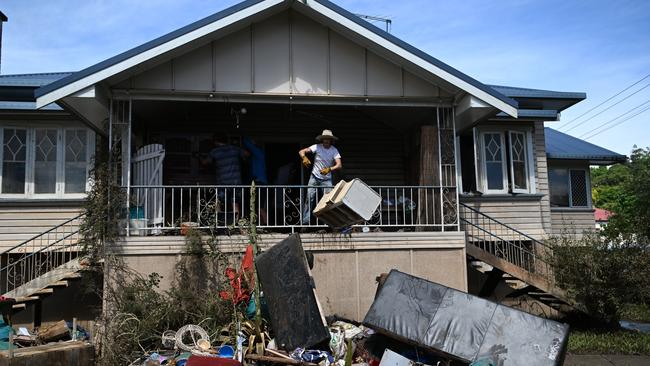 A man throws out damaged items at Lismore following the 2022 disaster. The Northern Rivers is still trying to recover from the floods more than two years later. Picture: Dan Peled/Getty Images