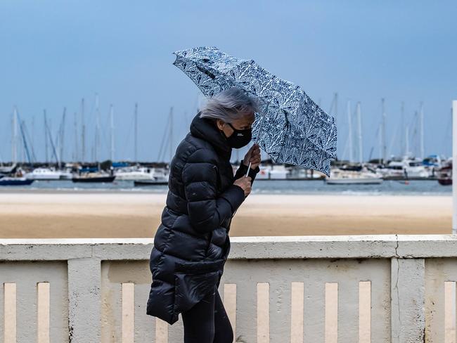 People battle a the rain and wind along Beaconsfield Pd St Kilda,  Melbourne Weather. Picture: Jason Edwards