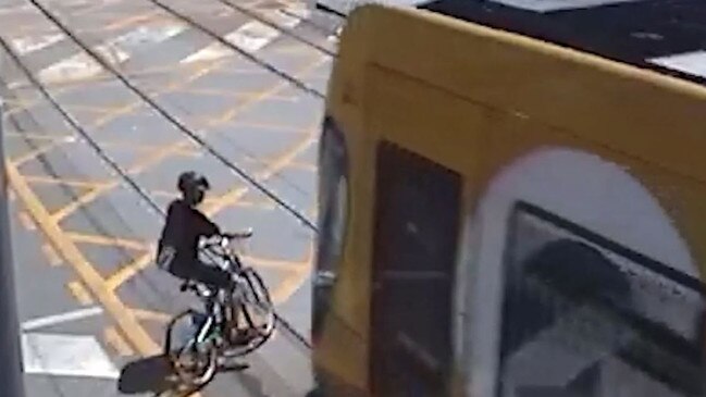 A cyclist crossing within inches of a moving tram. Picture: GoldlinQ