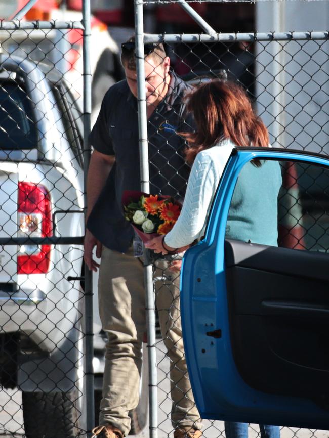 Flowers are left at the gate of the trucking yard.