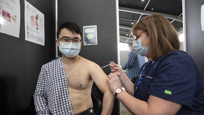 Mercury journalist Kenji Sato receives his vaccination from nurse Ann Richardson. Picture: Chris Kidd