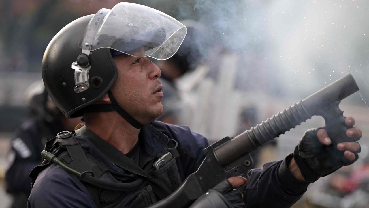 A police officer fires tear gas. Picture: Yuri CORTEZ / AFP