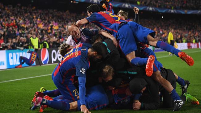 Sergi Roberto of Barcelona (obscured) celebrates with team mates.