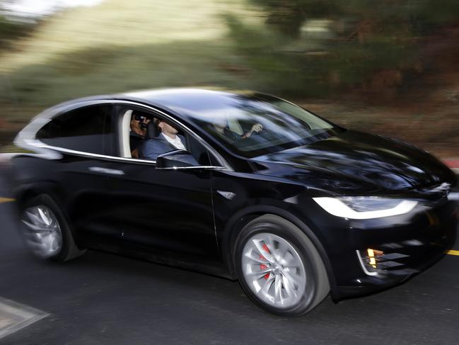 The Tesla Model X car is test driven at the company's headquarters Tuesday, Sept. 29, 2015, in Fremont, Calif. CEO Elon Musk says the Model X sets a new bar for automotive engineering, with unique features like rear falcon-wing doors, which open upward, and a driver’s door that opens on approach and closes itself when the driver is inside. (AP Photo/Marcio Jose Sanchez)