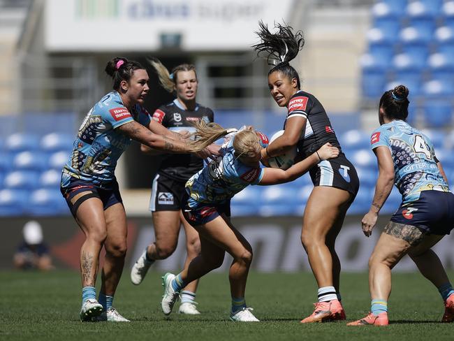 GOLD COAST, AUSTRALIA – AUGUST 31: Tiana Penitani of the Sharks is tackled by Lailani Montgomery of the Titans during the round six NRLW match between Gold Coast Titans and Cronulla Sharks at Cbus Super Stadium on August 31, 2024 in Gold Coast, Australia. (Photo by Russell Freeman/Getty Images)