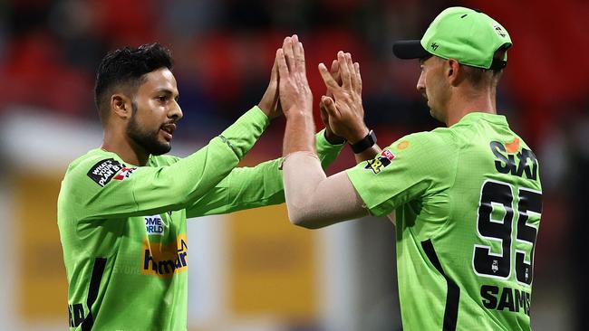 SYDNEY, AUSTRALIA - DECEMBER 12: Tanveer Sangha of the Thunder celebrates with Daniel Sams of the Thunder after dismissing Marcus Stoinis of the Stars during the Men's Big Bash League match between the Sydney Thunder and the Melbourne Stars at GIANTS Stadium, on December 12, 2021, in Sydney, Australia. (Photo by Cameron Spencer/Getty Images)