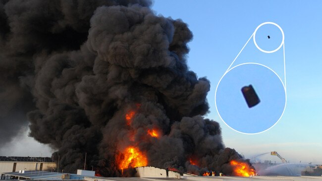 Explosions sent 44-gallon drums flying high into the air over the Campbellfield factory fire. Picture: Andrew Henshaw