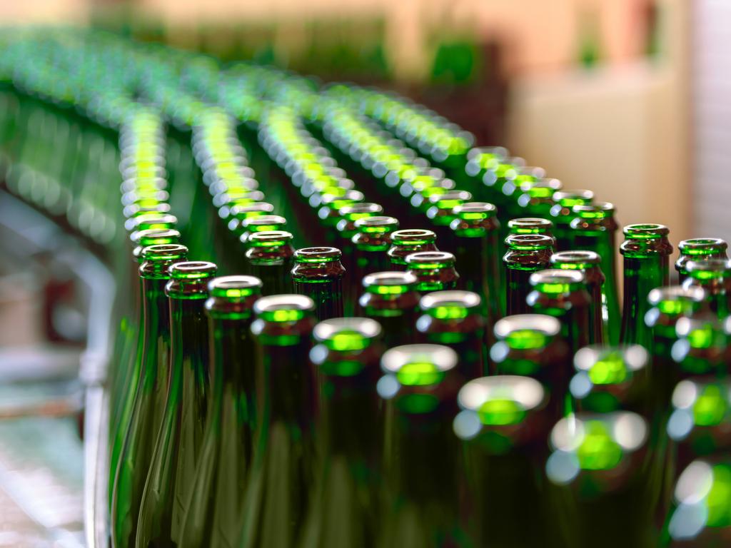 Many bottles on conveyor belt in factory