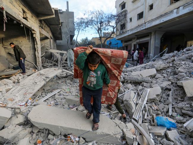 People inspect the damage and extract items from their homes after the Al-Masry Tower was targeted by Israeli air strikes in Rafah, Gaza. Picture: Ahmad Hasaballah/Getty Images