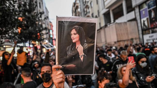 A protester holds a portrait of Mahsa Amini during a demonstration.