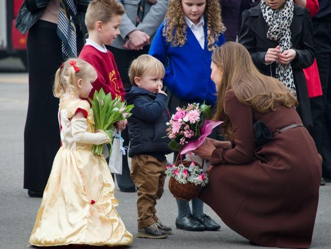 One for the album ... a little boy picks his nose as he talks to Catherine, Duchess of Cambridge during her visit to Peaks Lane fire station in Grimsby, northern England.