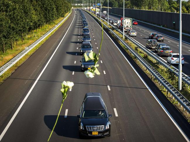 Flowers are dropped onto the hearses of the victims of MH17 from onlookers paying their respects. Picture: Remko De Waal