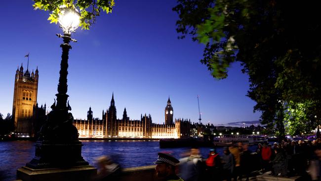 A police officer stands guard as members of the public stand in line as they queue along Embankment, with the Palace of Westminster, house of Parliaments and Big Ben in the background. Picture: AFP