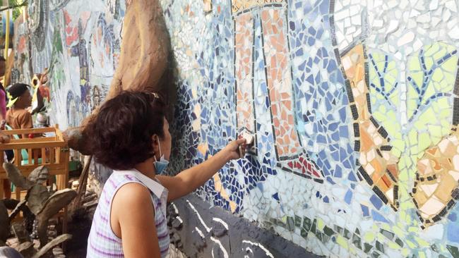 Maryann works on a mural in a church yard in Manila. Picture: <span class="creditattribution">Amanda Hodge</span>