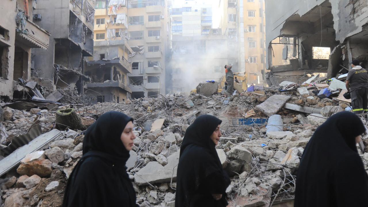 People walk past the rubble of a building at the site of an Israeli strike on the Basta neighbourhood in the Lebanese capital Beirut on October 11, 2024. Picture: AFP.