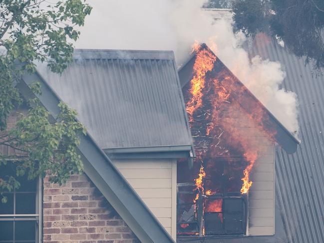 SYDNEY, AUSTRALIA - NewsWire Photos November 29, 2020: A house on fire on Whitehaven Road, Northmead, Sydney. A bushfire started nearby and spread to the house, with Fire and RFS crews on scene to try and control the bushfire and the house fire. Picture: NCA NewsWire / James Gourley