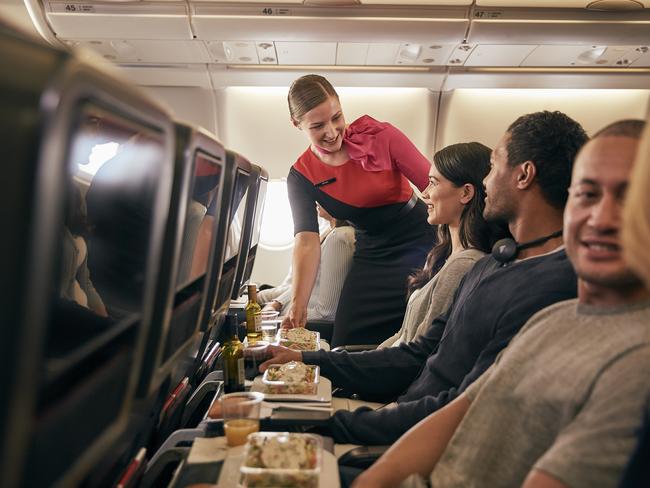 From Jan 20, Qantas will be offering direct seasonal flights from Sydney to Sapporo’s New Chitose Airport, to help make it easier for travellers to reach Hokkaido’s world-class ski resorts on Japan's northernmost island. Picture: Supplied/Qantas.    Inflight economy cabin passengers are getting food served in Qantas A330