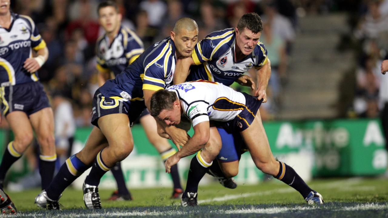 Shaun Berrigan gets tackled by Paul Rauhihi and Broncos vs Cowboys at Dairy Farmers Stadium T'ville . NRL 18.9.04